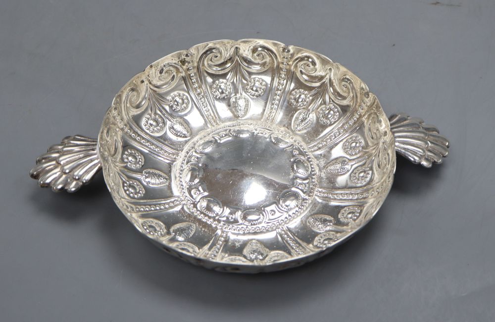 An Edwardian repousse silver shallow bowl, with fluted lug handles, Wakely & Wheeler, London, 1906, 24.7cm, 8.5oz.